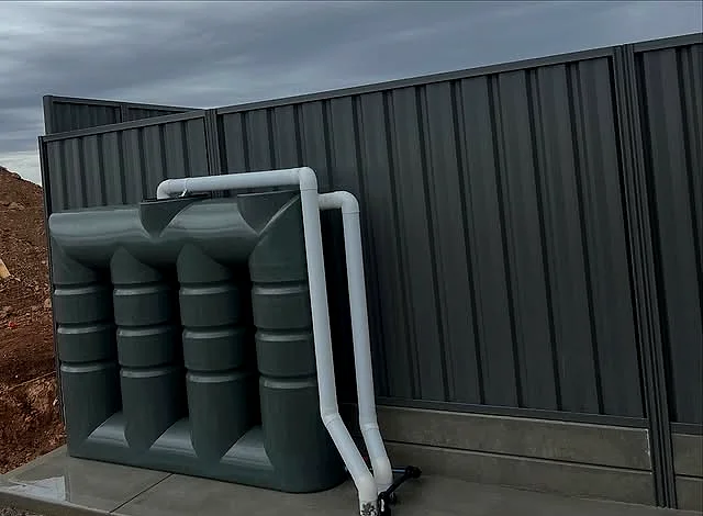 Black stormwater detention and soakwell modules with a downpipe